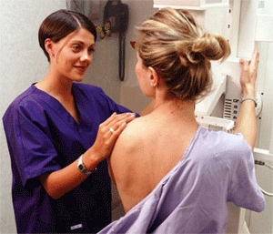 Doctor assisting female patient during mammography